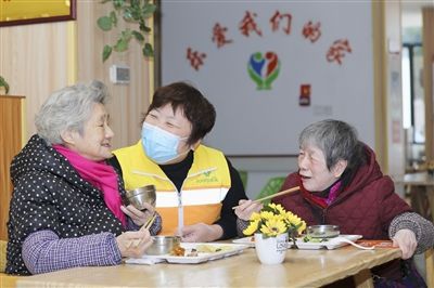 福建省福州市鼓楼区安泰街道社区智慧养老服务照料中心工作人员在询问老人用餐情况。