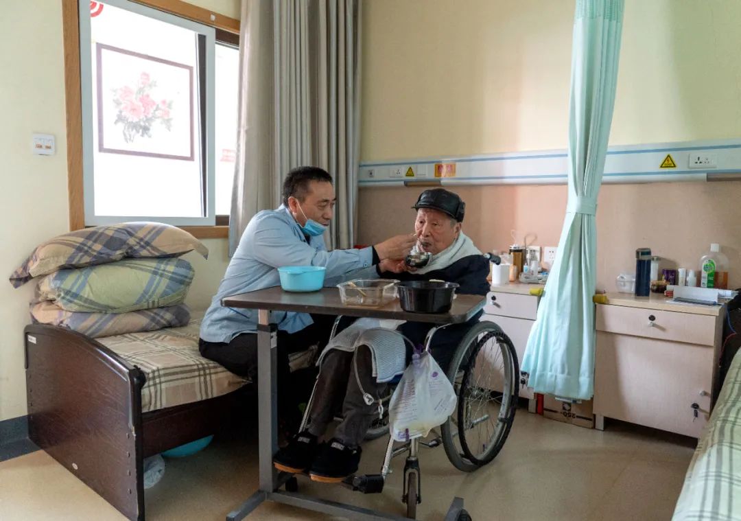 在北京市西城区展览路街道养老照料中心，护理员郭相旭为老人喂饭 才扬 摄